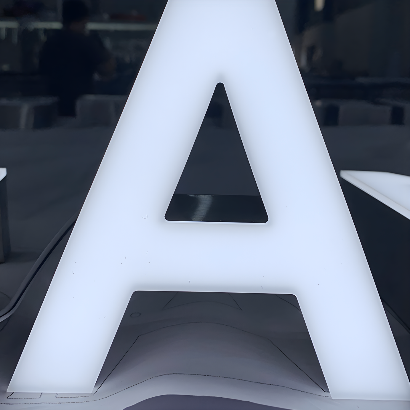 Premium trimless front-lit LED letters glowing on outdoor wall