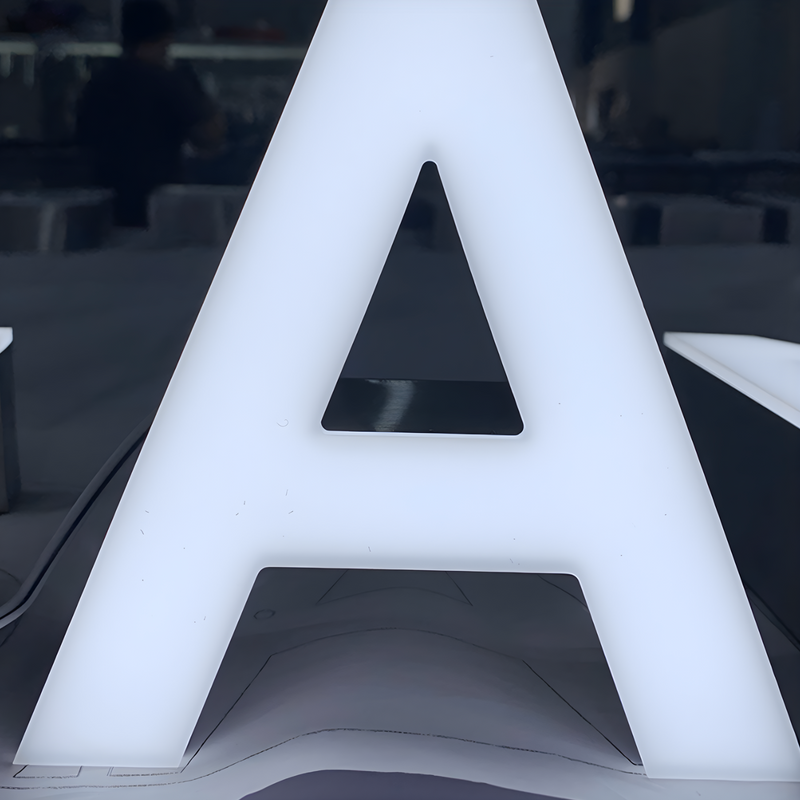 Premium trimless front-lit LED letters glowing on outdoor wall